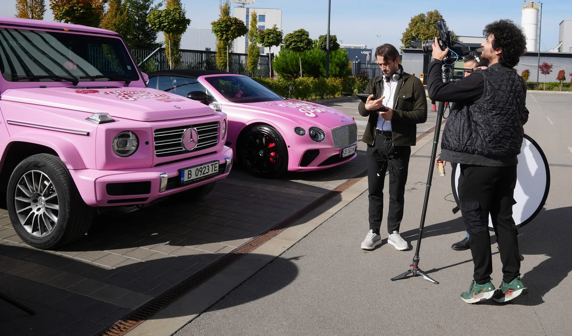 Martin Mednikarov on location with a camera operator beside two pink cars