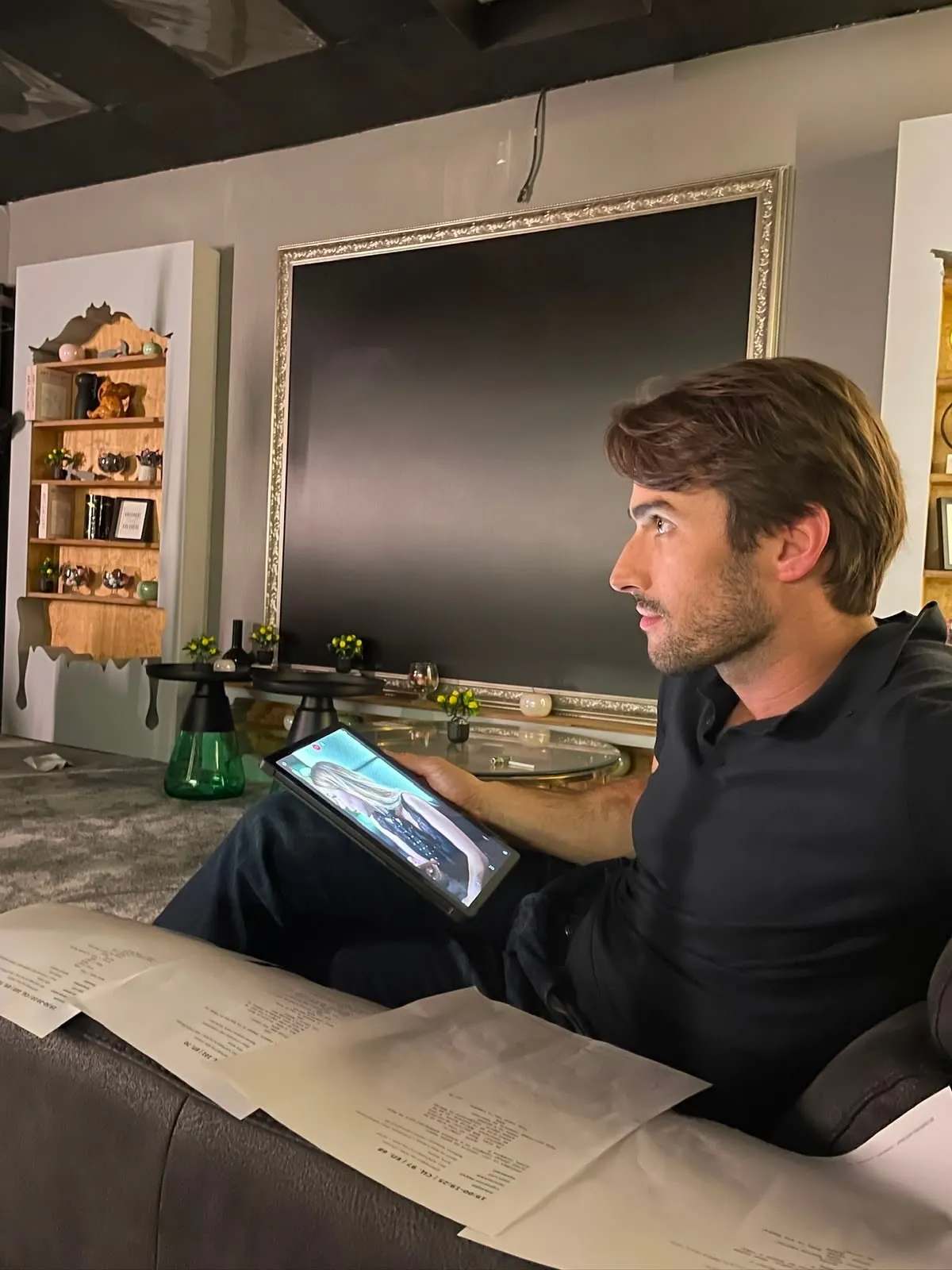 Martin Mednikarov reviewing a video on a tablet with script pages in front of him